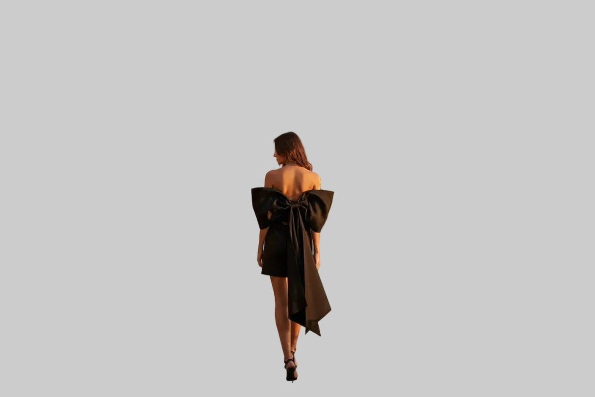 Woman walking along a path in front of a luxurious villa with ocean views.