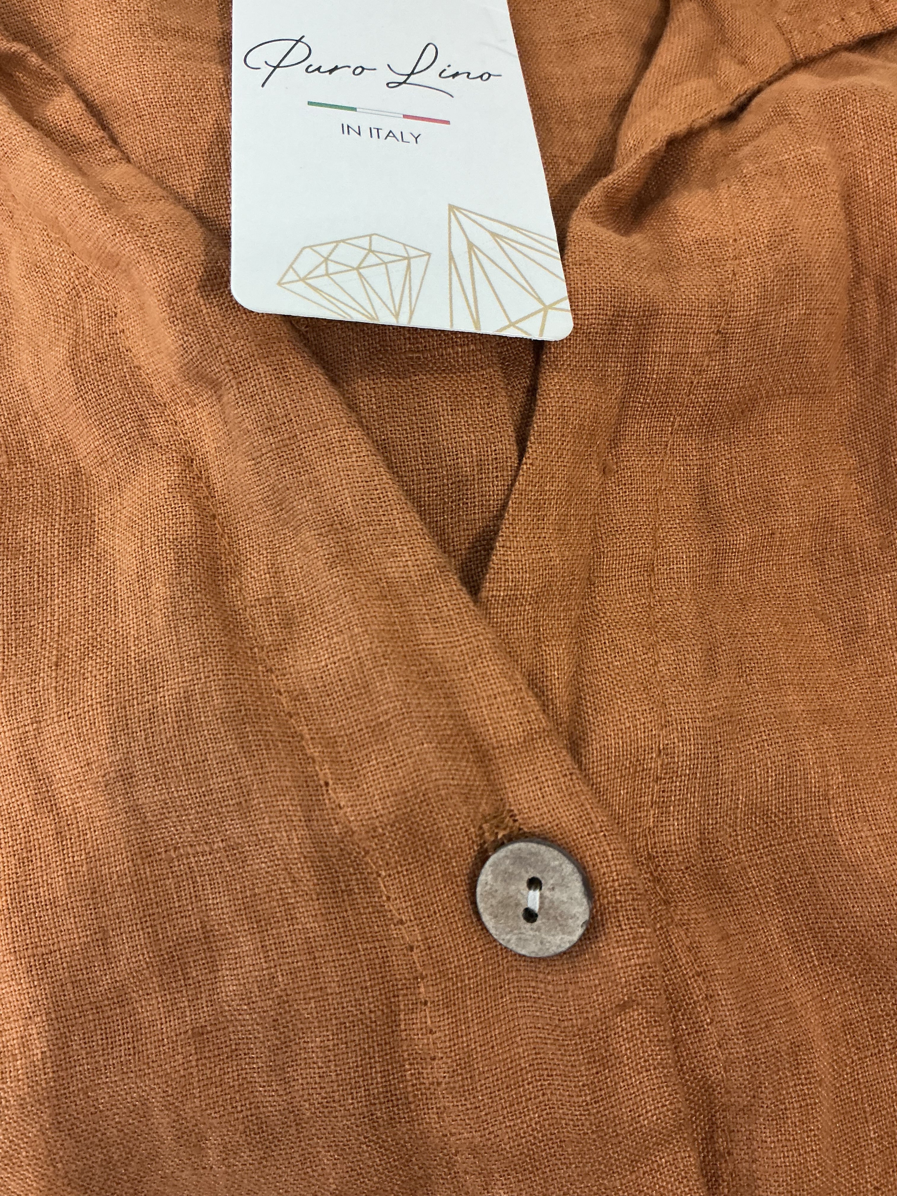 Close-up of brown fabric with a button and a brand tag.