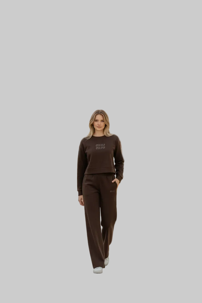 Woman wearing a brown Miu Miu tracksuit in a modern living room.