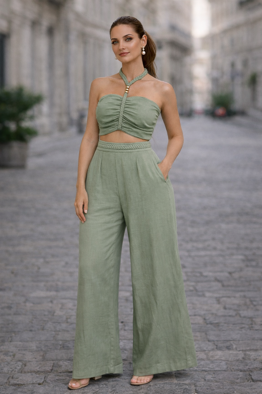 Woman wearing a green outfit standing on a stone street.