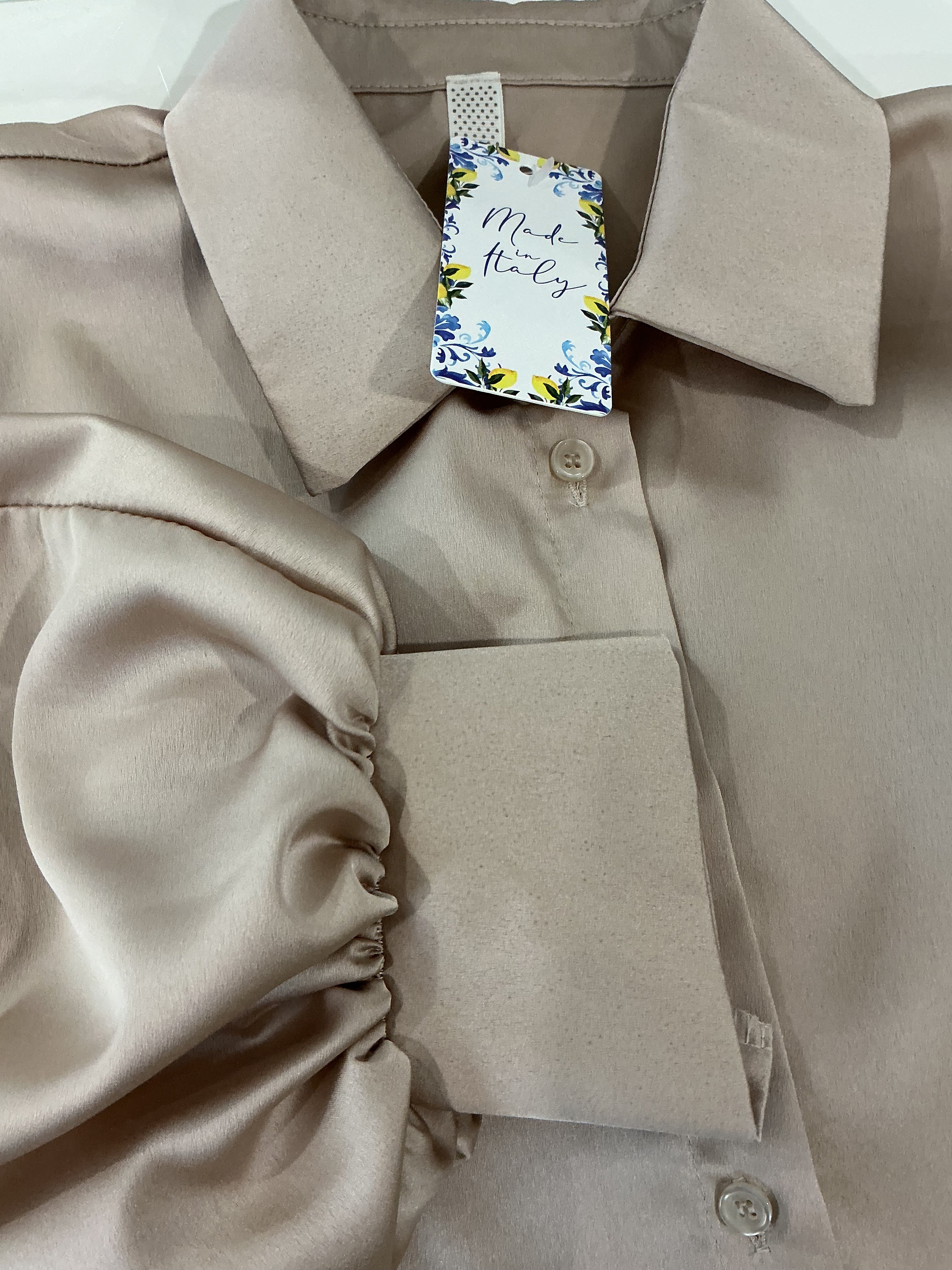 Close-up of a beige dress with a tag on a white background